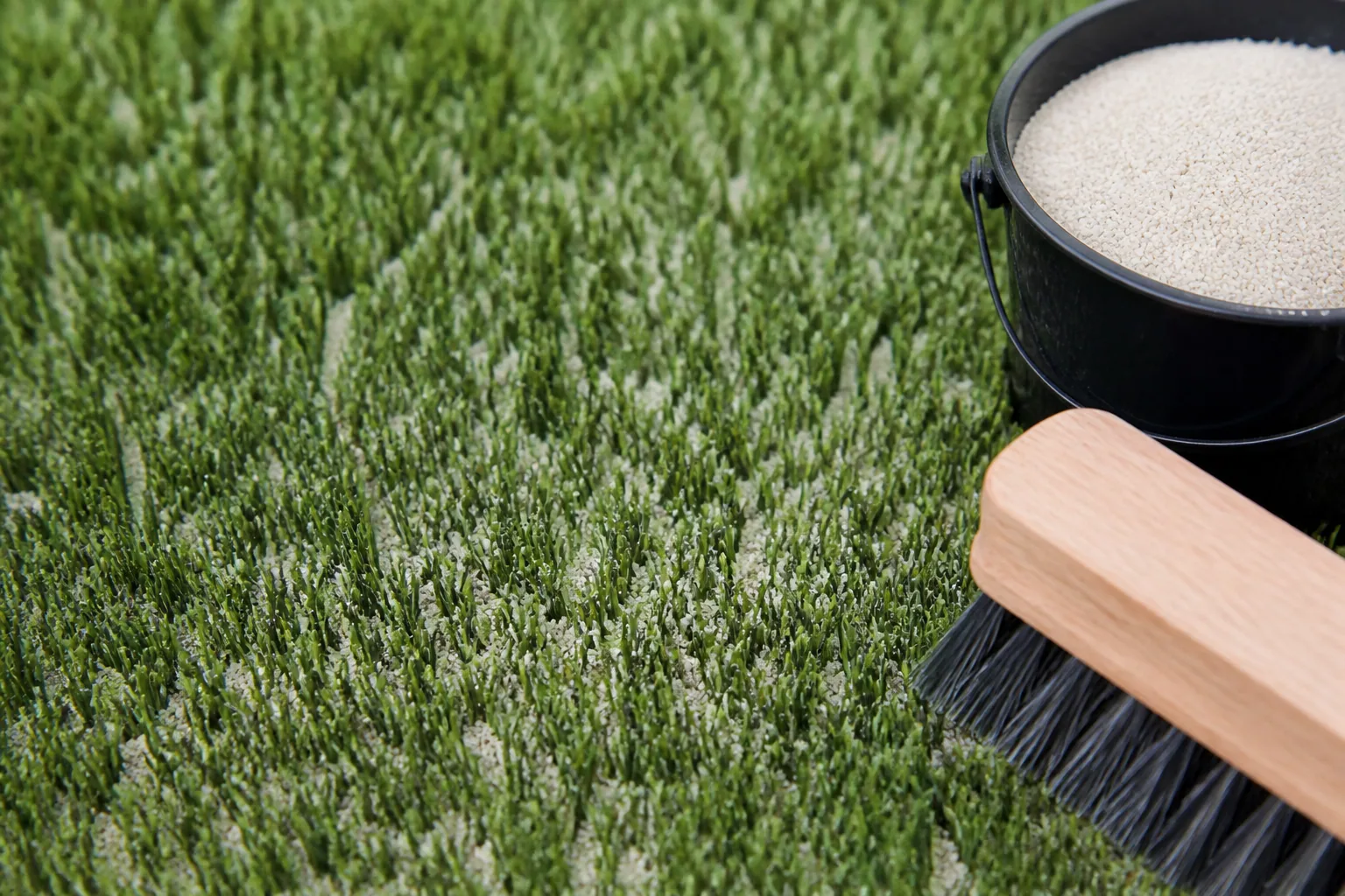 Sable de silice réparti dans les fibres d’un gazon synthétique